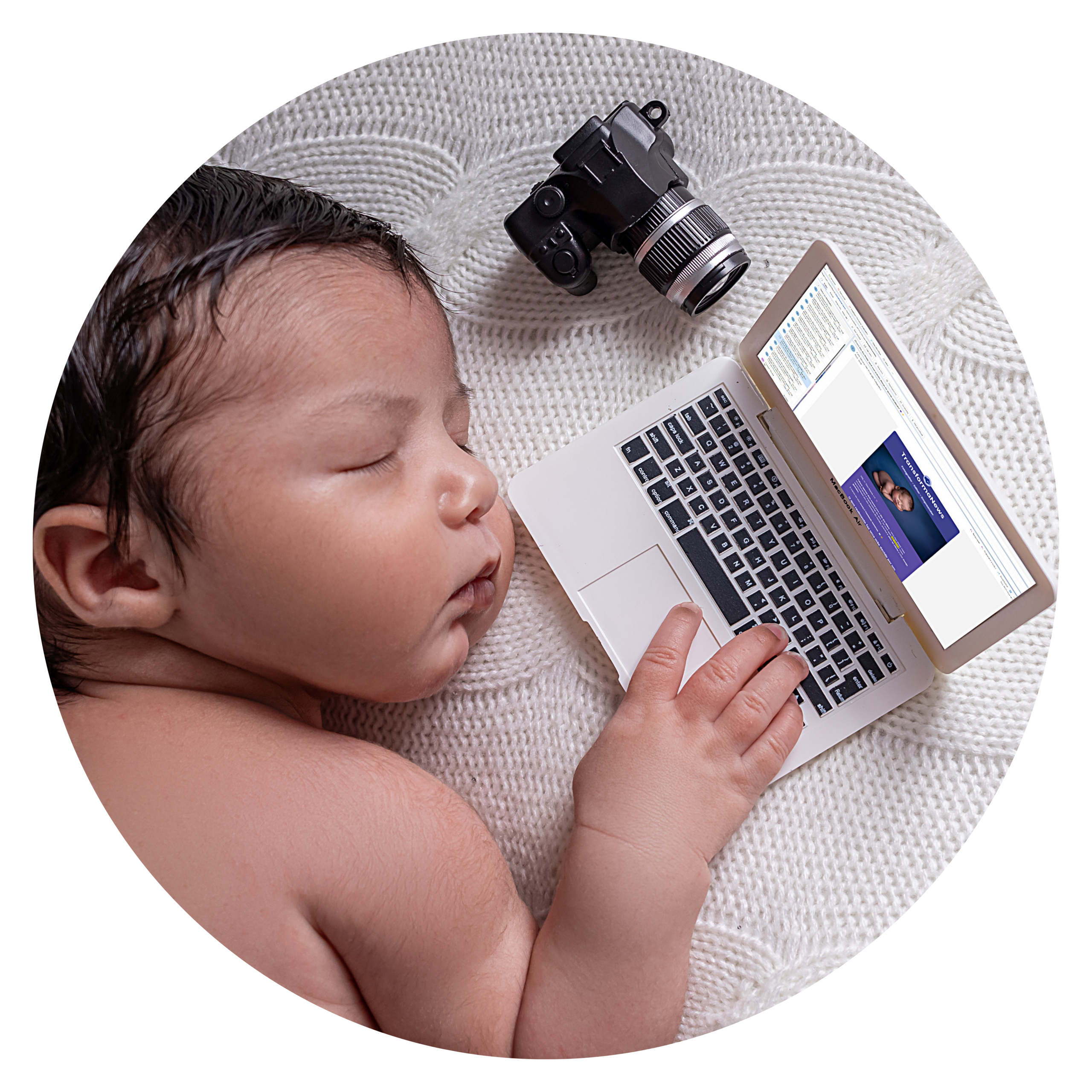 Bebê dormindo ao lado de um laptop e uma câmera, sobre manta branca