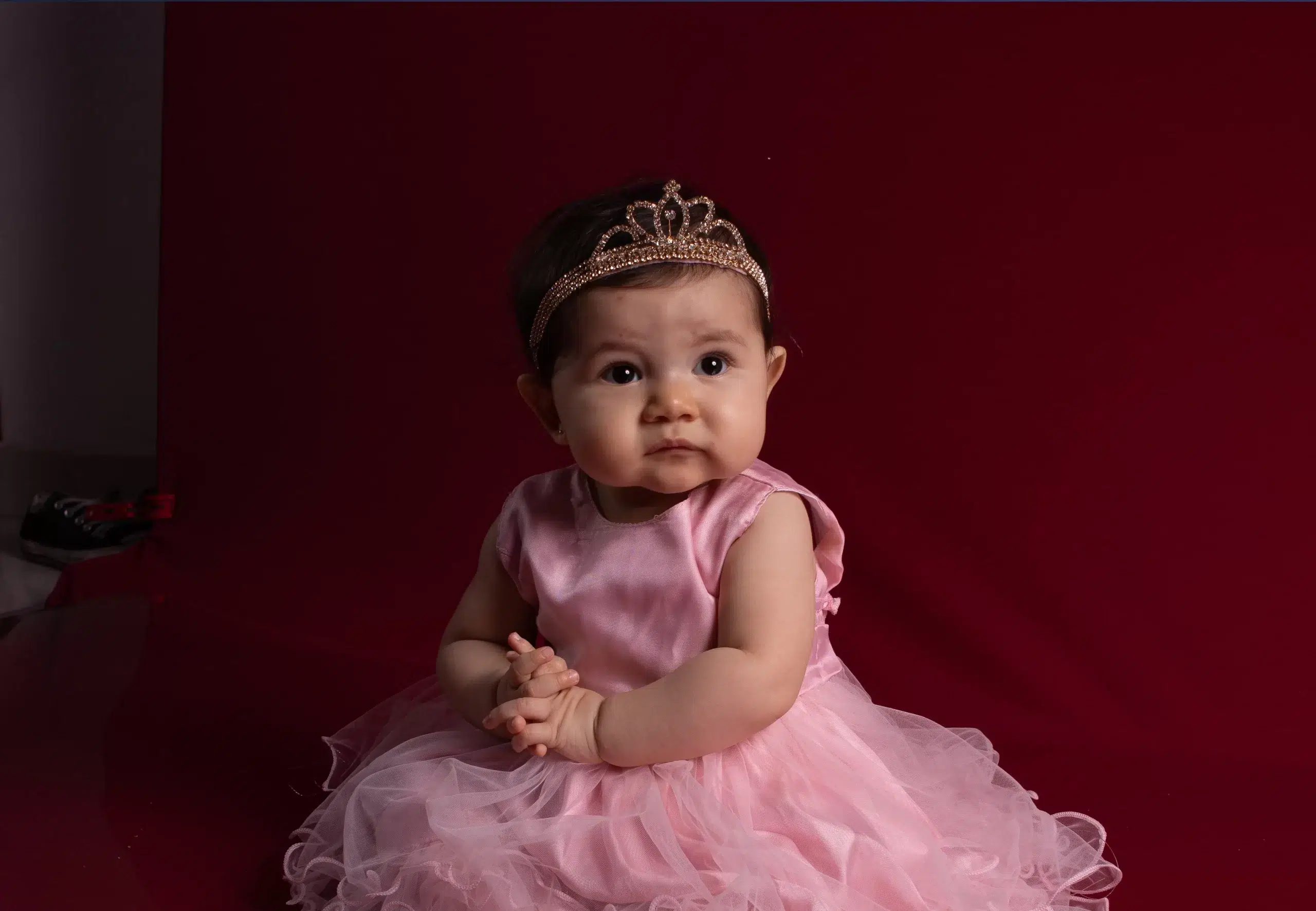 Transforme suas fotos com uma pós-produção humanizada e profissional 5 Bebê usando vestido rosa de princesa com tiara dourada, antes da pós-produção